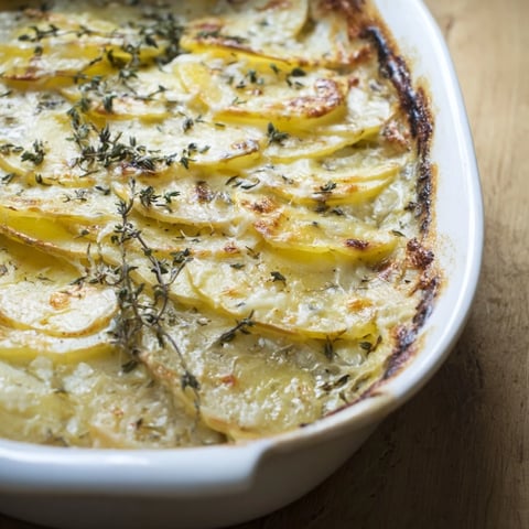 Kremoßer Kartoffel- und Käsegratin mit goldbrauner Kruste und schmelzenden Käseschichten.
